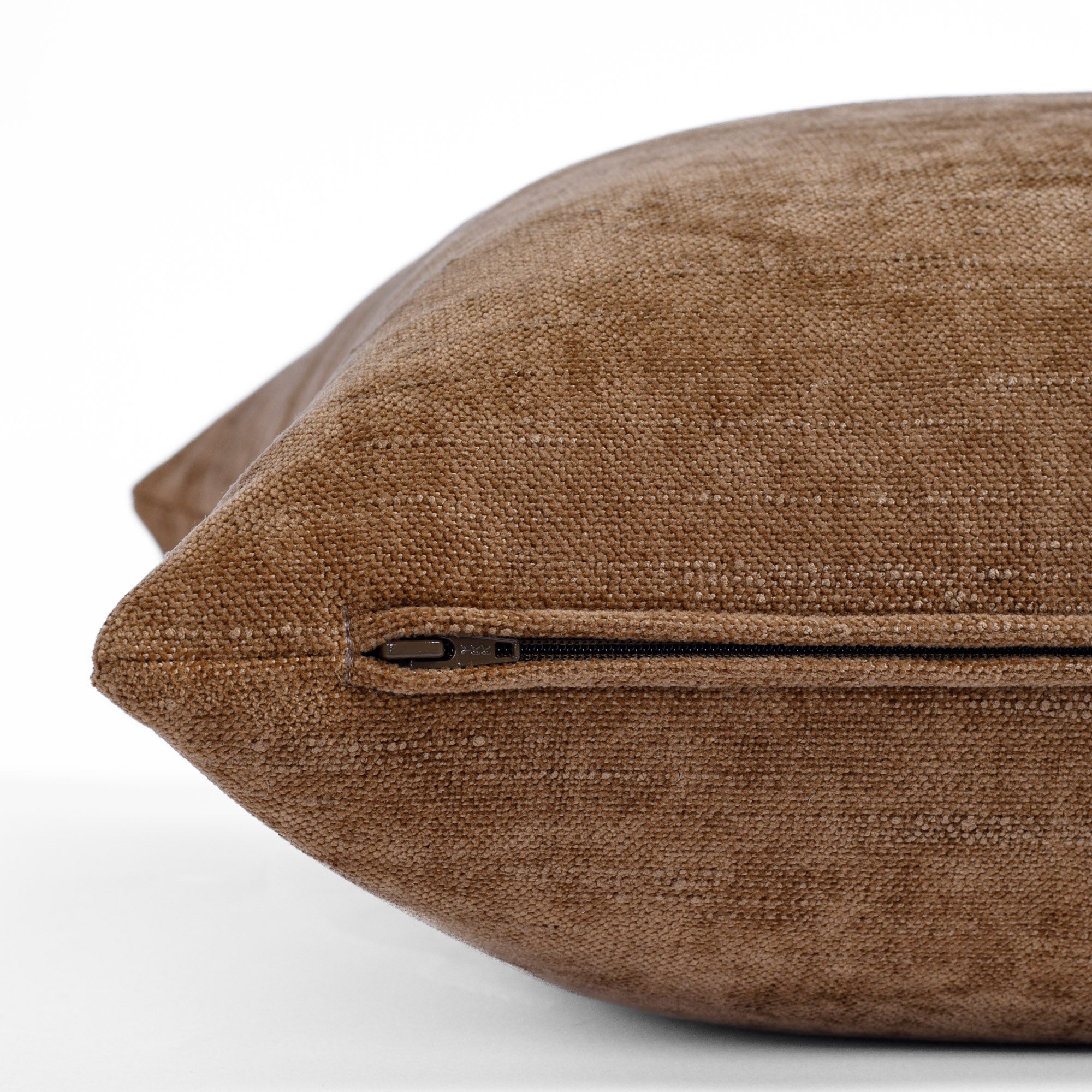 an earthy brown chenille throw pillow: close up zipper view