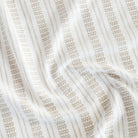 a white and tan intricate woven striped home decor fabric with a European flair