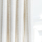 a white and beige woven stripe patterned curtain fabric : close up view