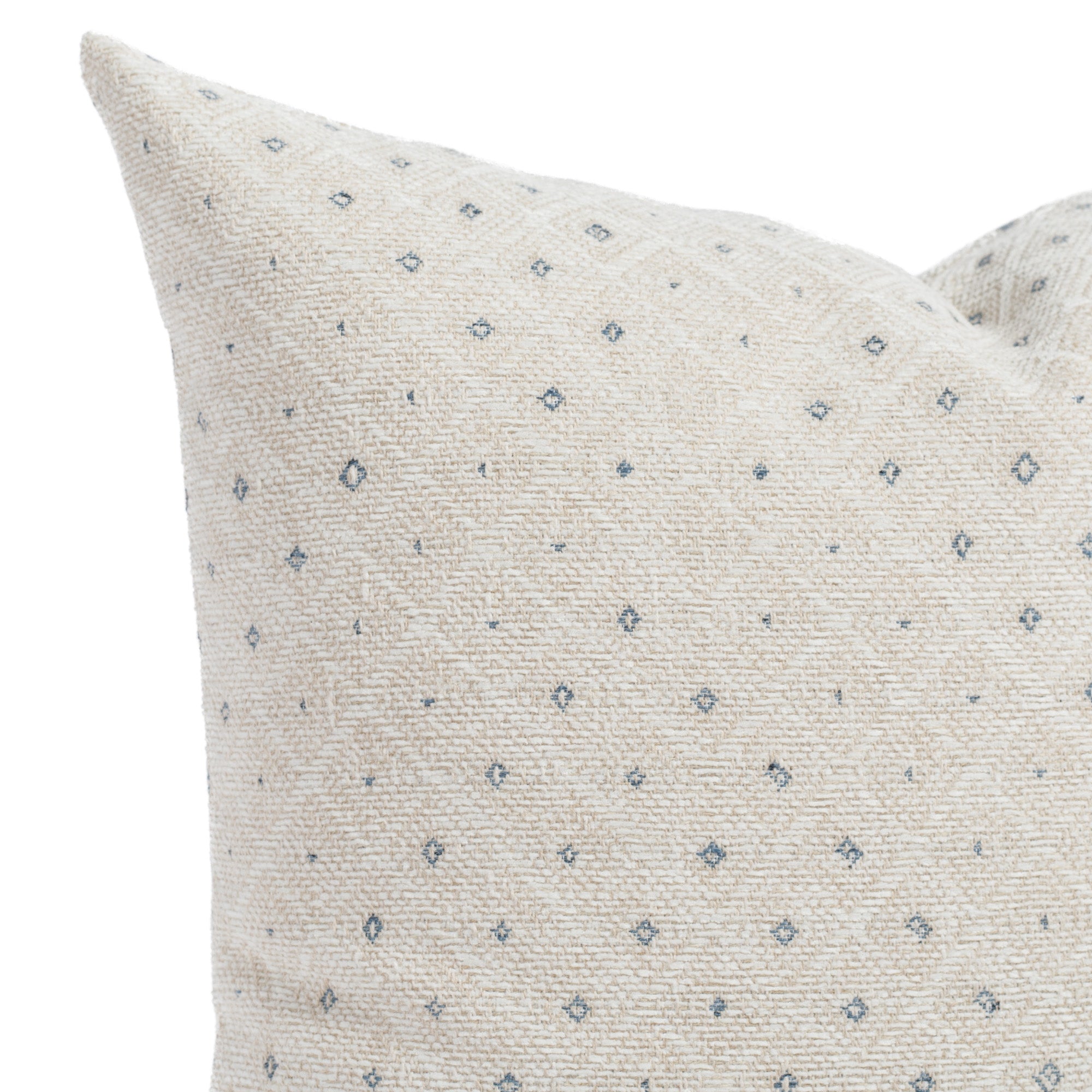 A beige, denim blue and white pillow: a close up view.