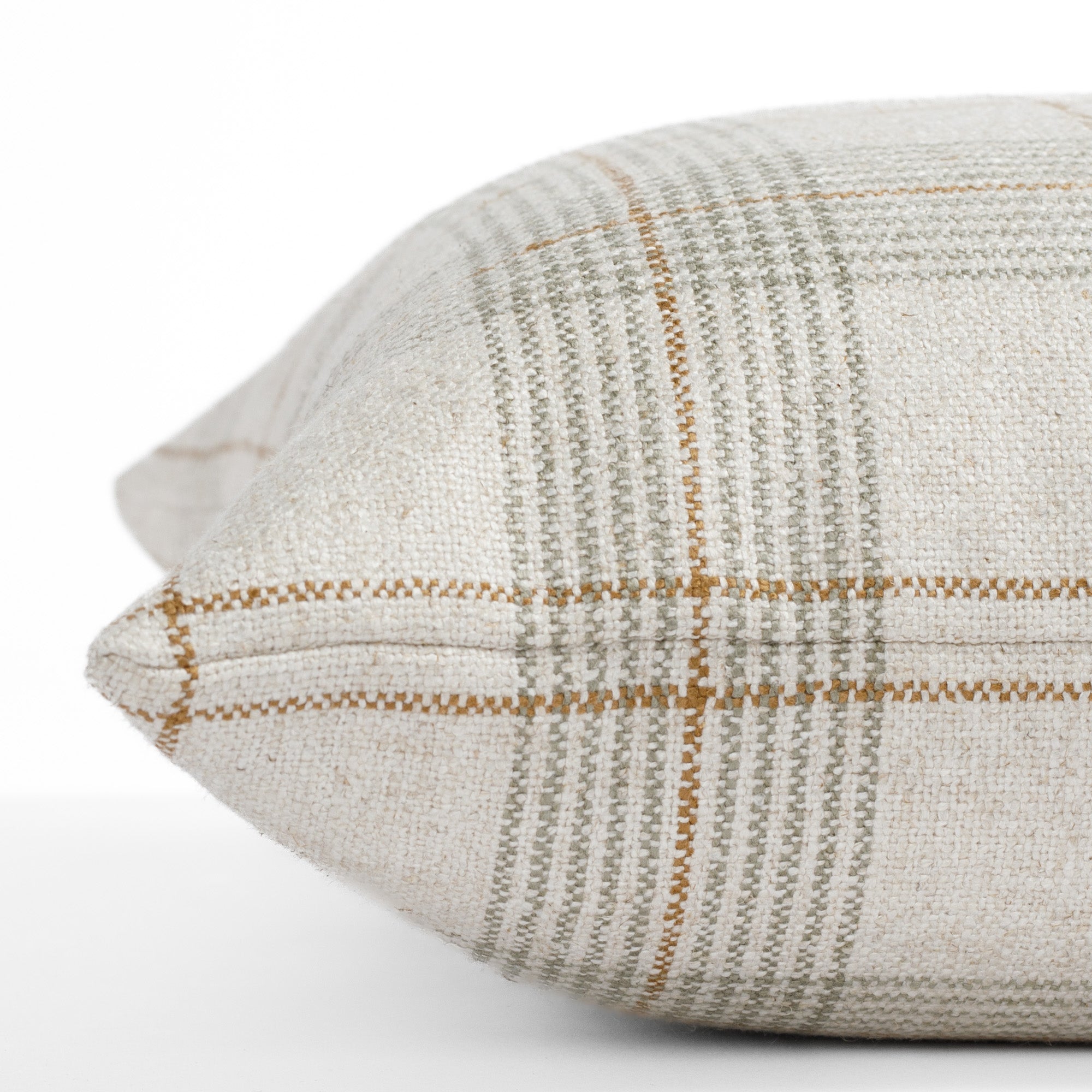 A neutral plaid pillow: close up side view.