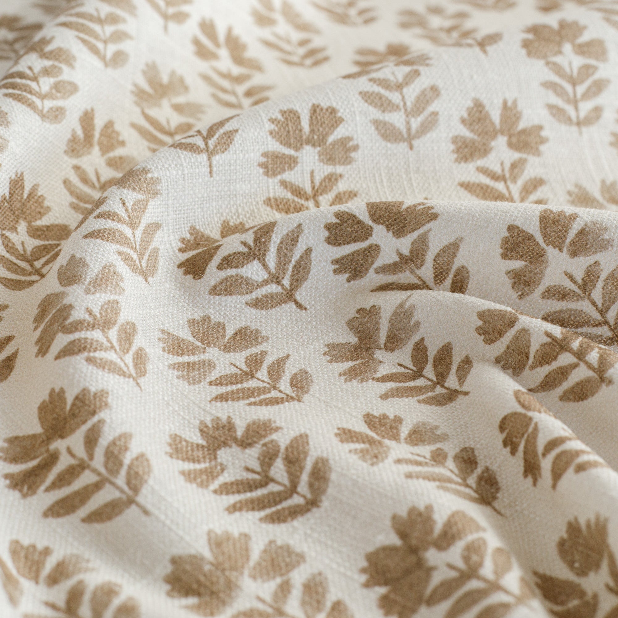 an oatmeal and brown floral block-print fabric : close up view