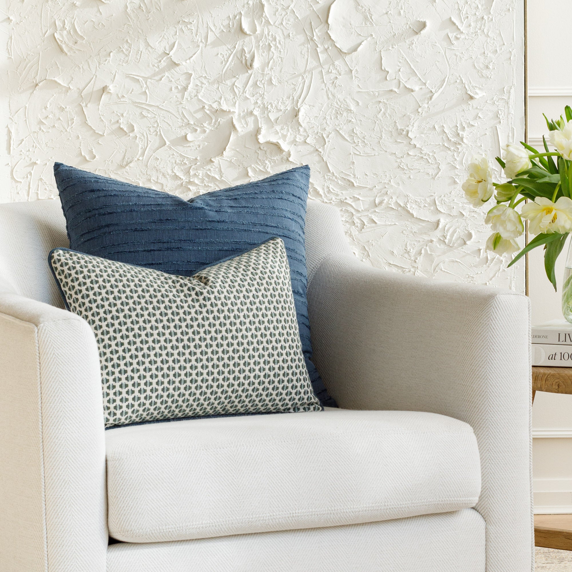 Blue-toned toss pillows from Tonic Living, styled on furniture.