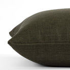 a deep green throw pillow : close up side view