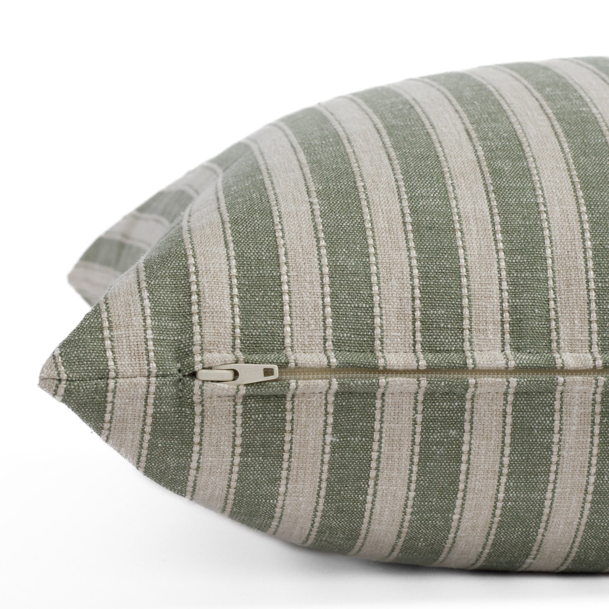 A sage and oatmeal striped pillow: close up zipper view.