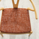 an earthy rust red upholstered chair seat